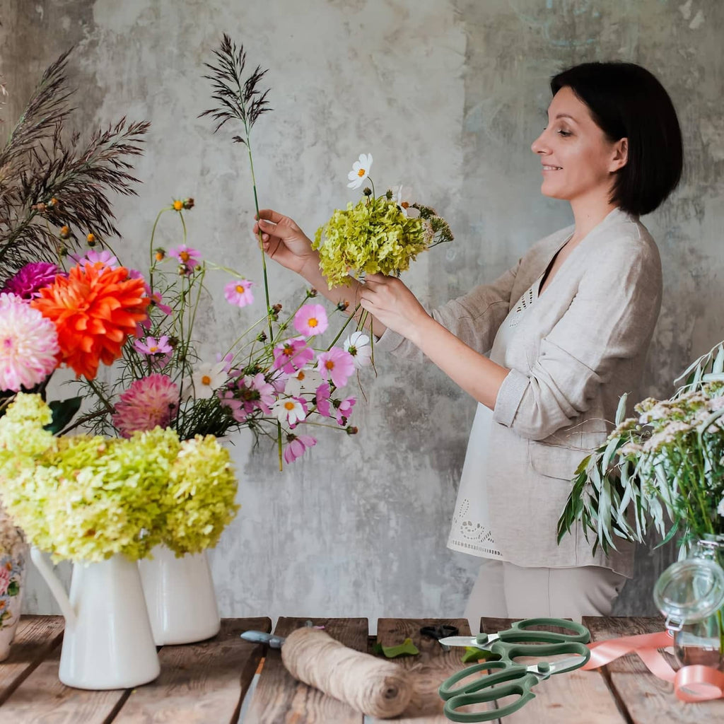 Mint green flower shears near vases of fresh cut flowers