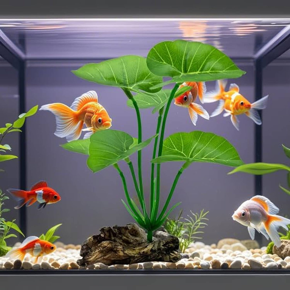 Artificial aquarium plant with green leaves in tank with orange and white fish
