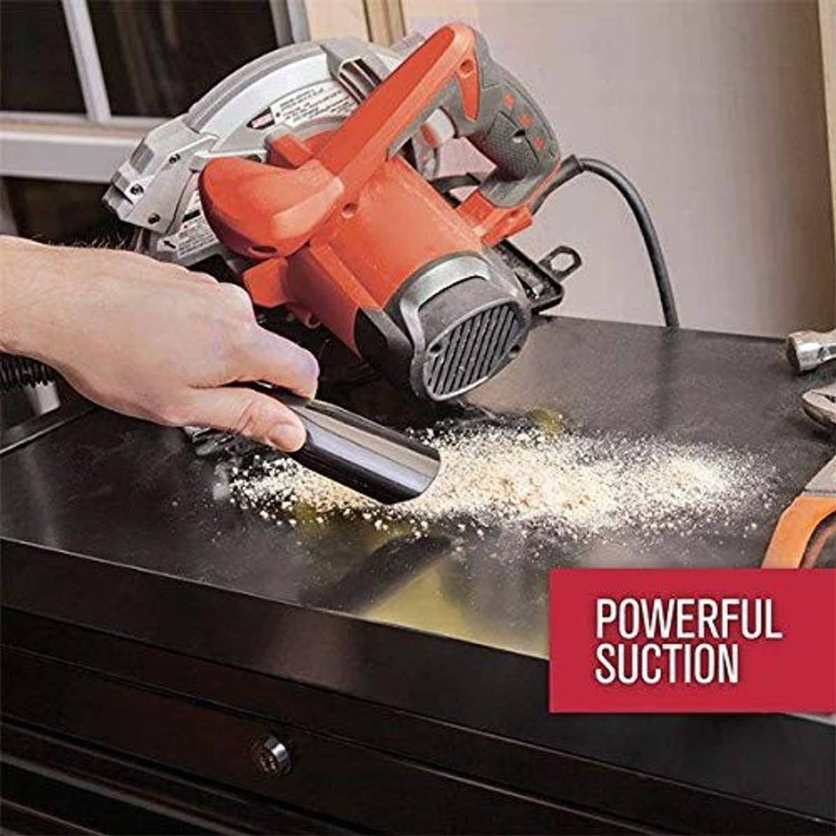 Red handheld vacuum head cleaning floor dust and debris with hose attachment