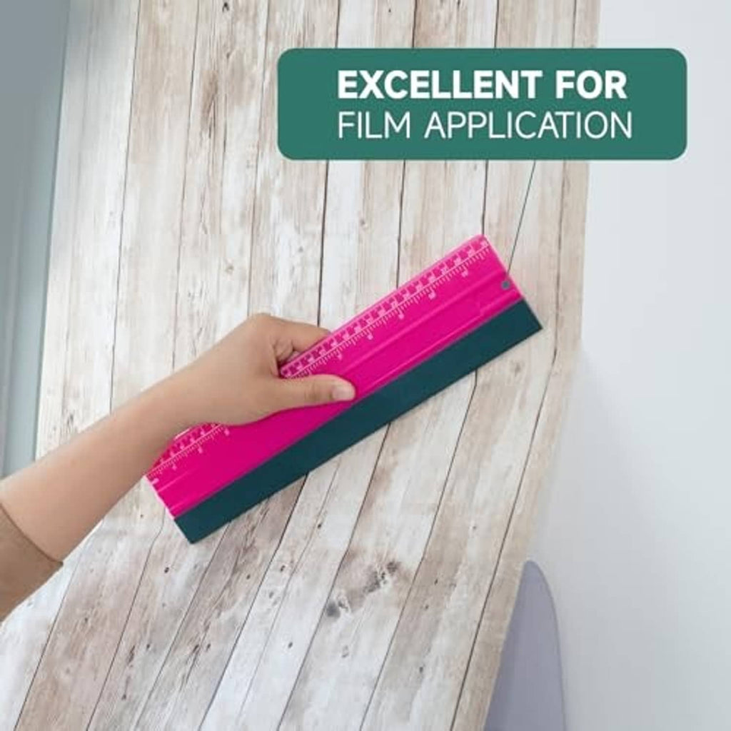 Pink squeegee with dark green felt edge held over film application surface