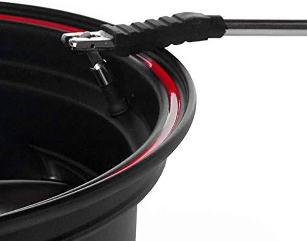 Valve stem puller/installer tool tip contacting the valve stem on a black tire rim.