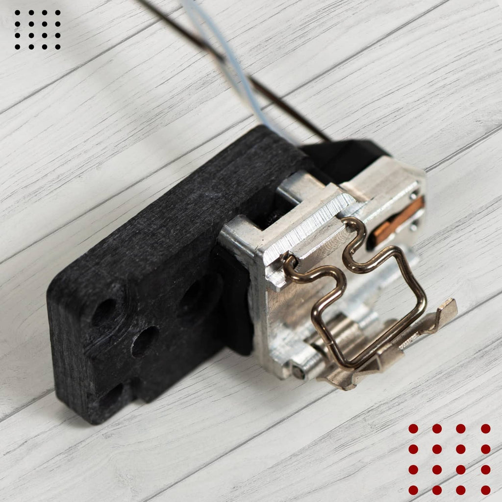 Hotend heating assembly close-up: metal bracket, clamp springs, and black base