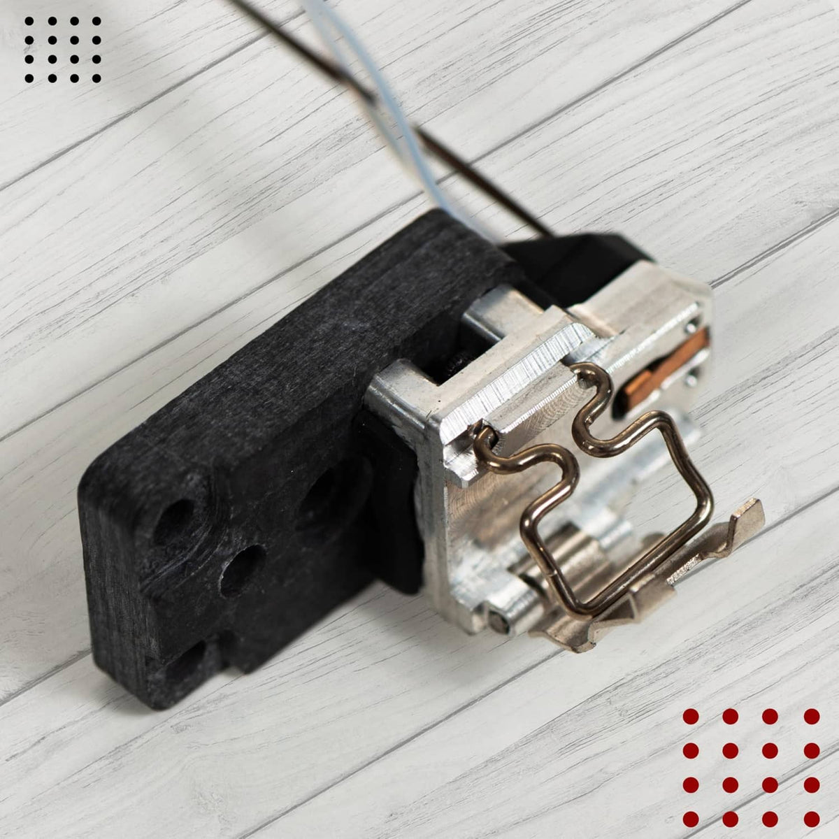 Hotend heating assembly close-up: metal bracket, clamp springs, and black base