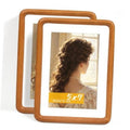 Two 5x7 teak wood picture frames with rounded corners and clear glass front