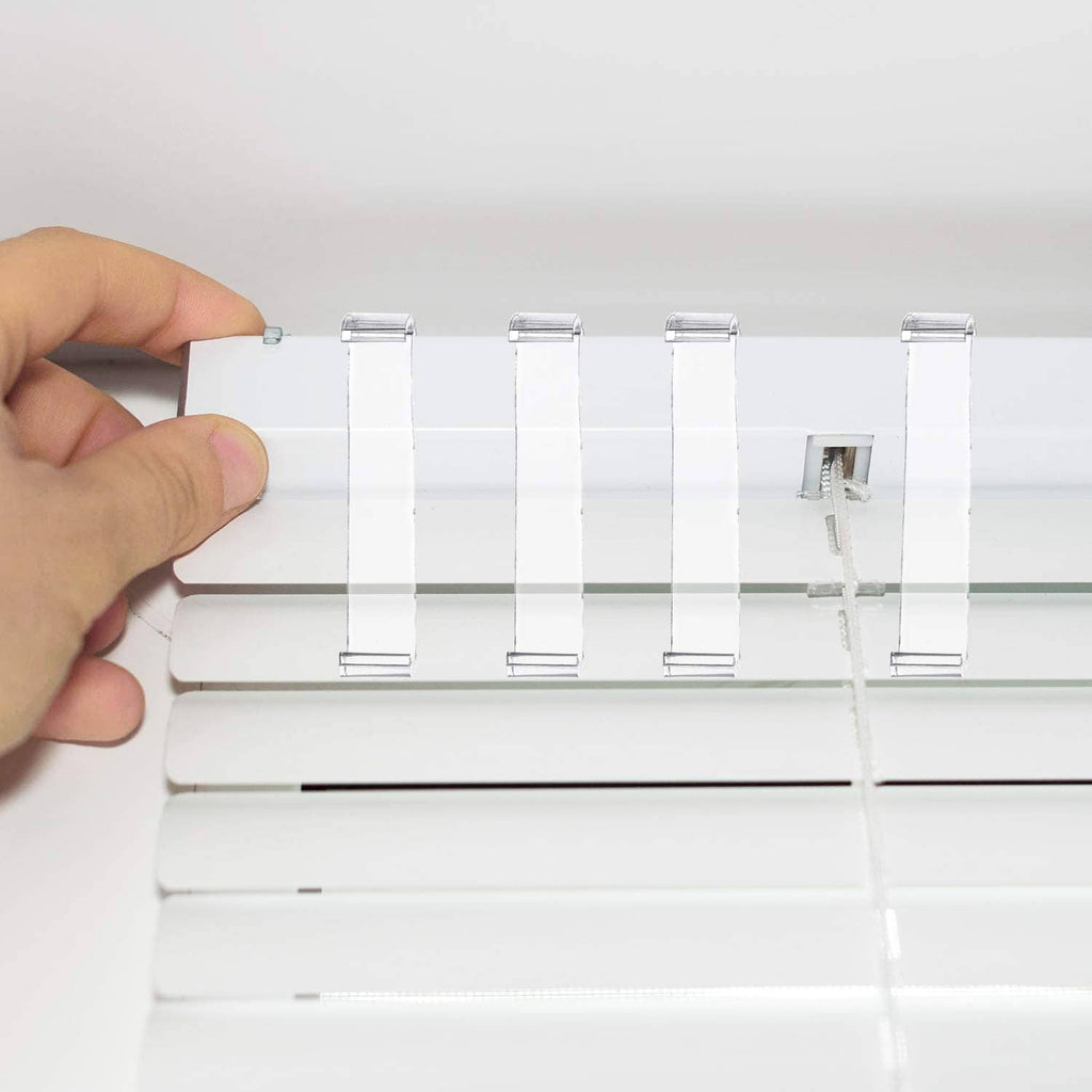 Set of clear plastic blind valance clips attached to a white window blind