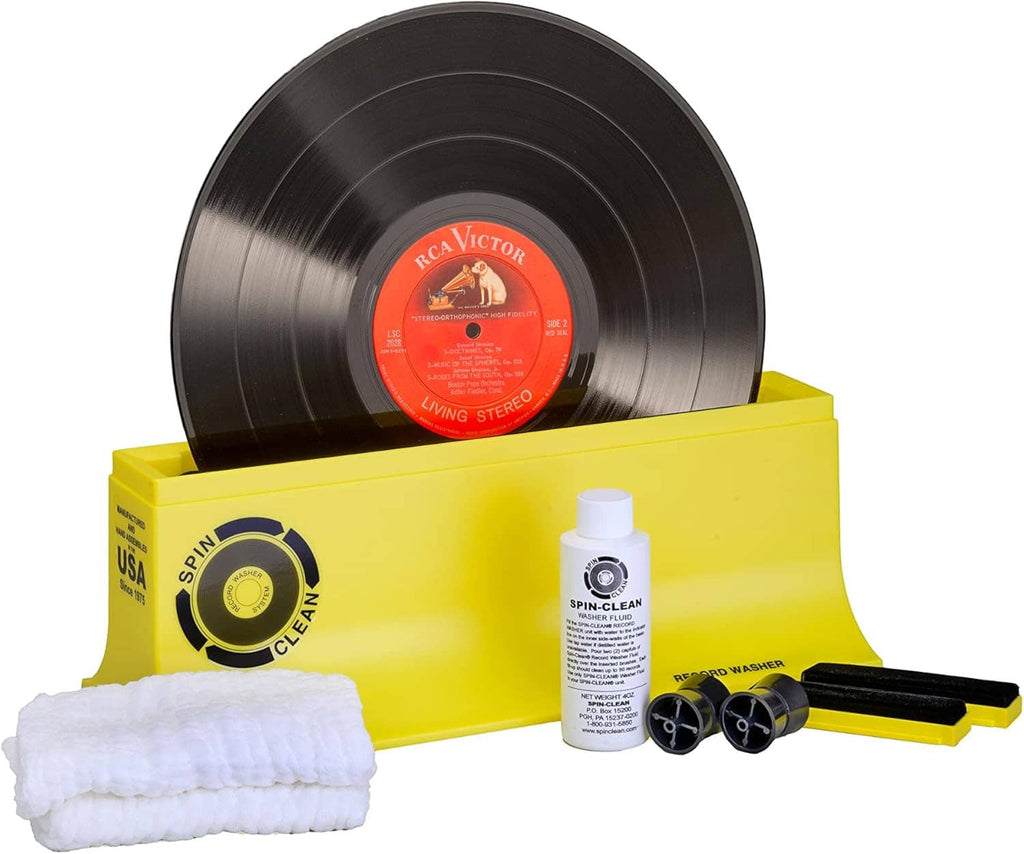Vinyl record cleaner kit with vinyl record, yellow case, bottle, and cloth