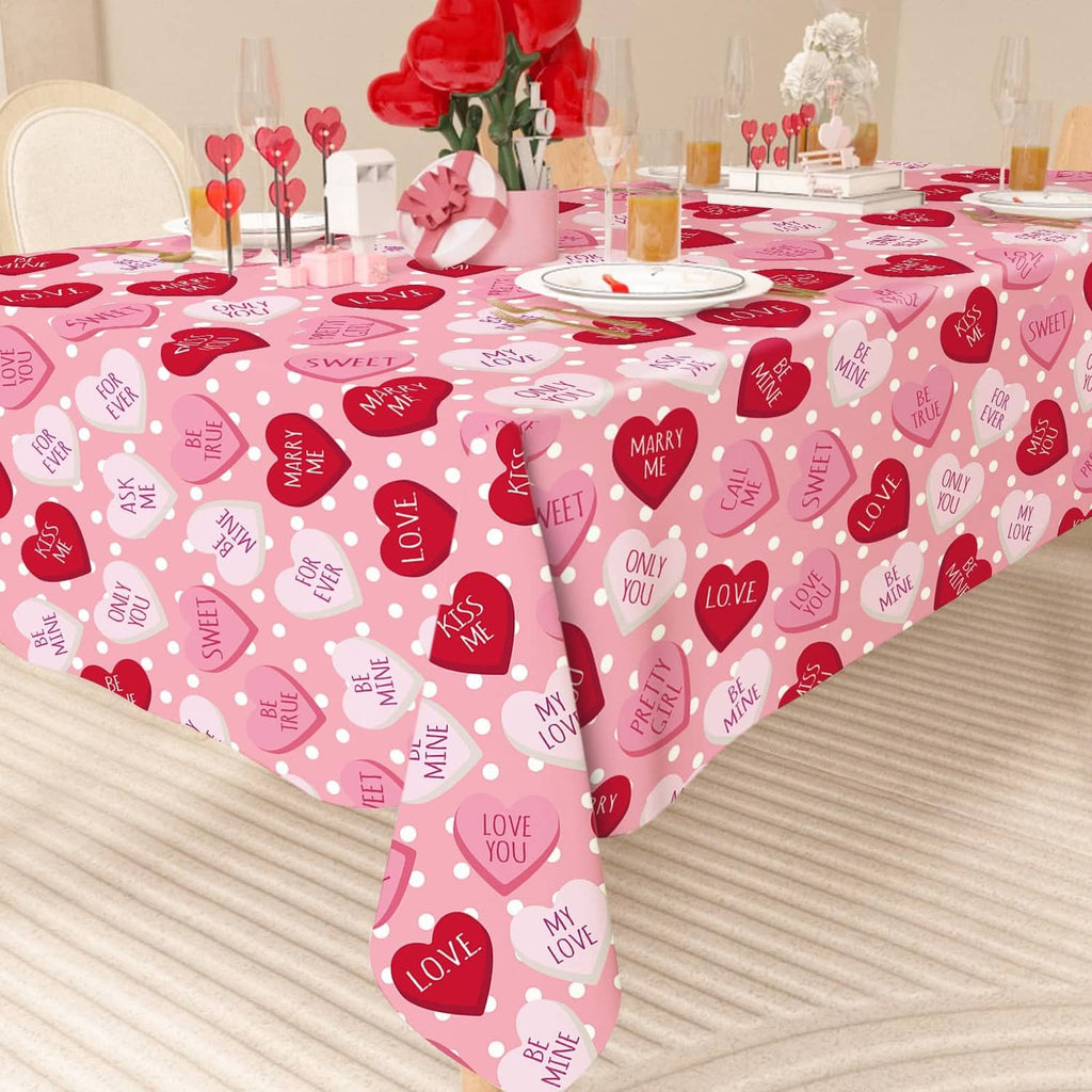 Pink rectangular tablecloth patterned with red heart shapes and small love text icons