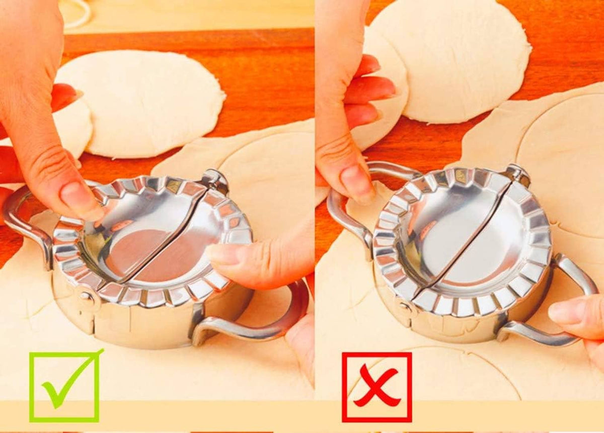 Stainless steel dumpling press forming dumplings on dough sheet with hands adjusting