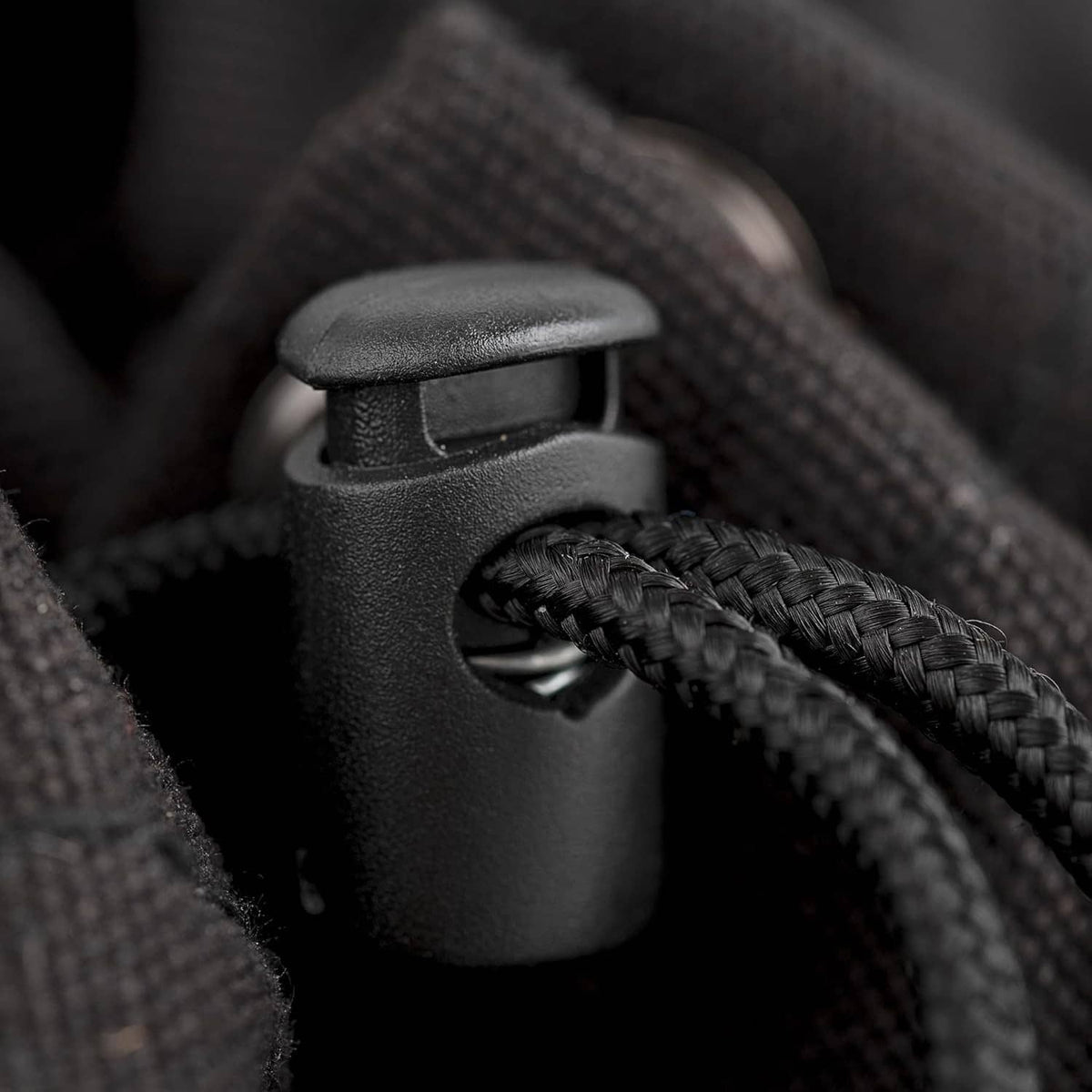 Close-up of black cord and plastic latch detail on parachute bag