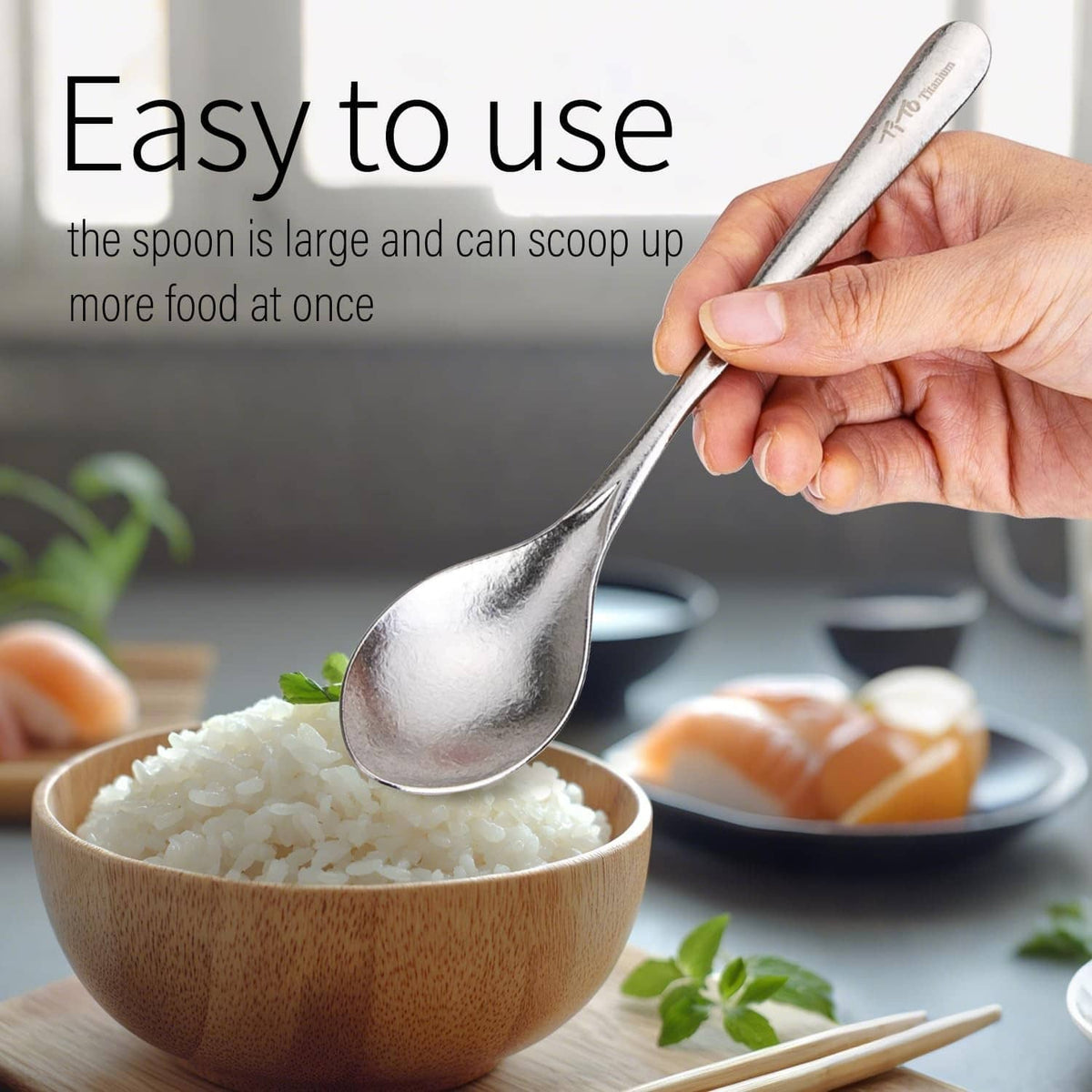 Silver titanium spoon with oval bowl and long handle, held above rice