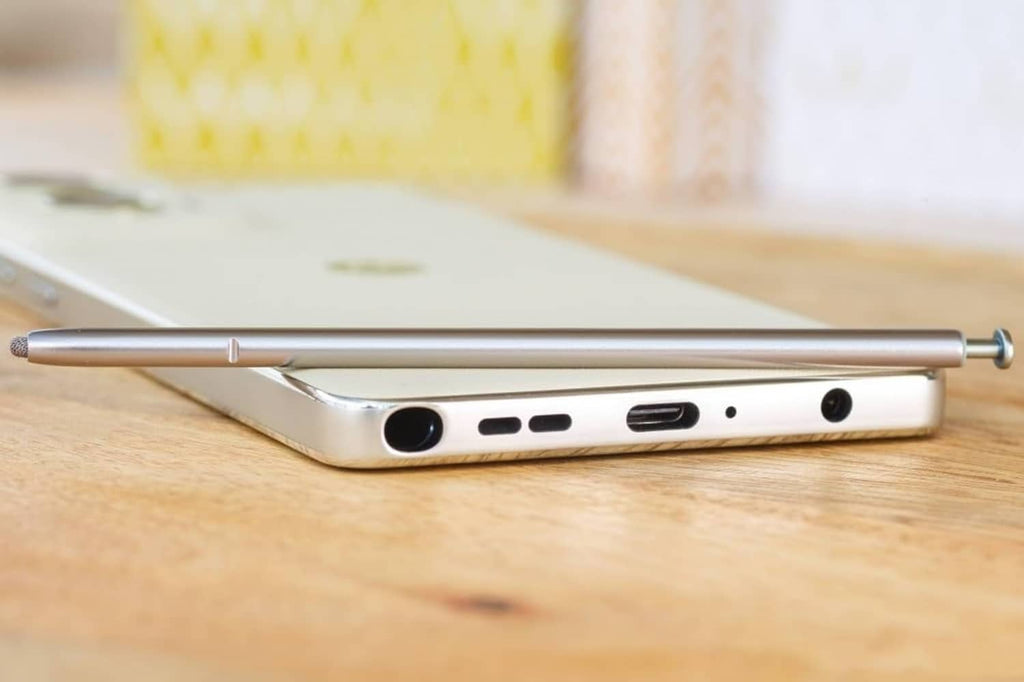 Metal stylus pen resting beside a smartphone