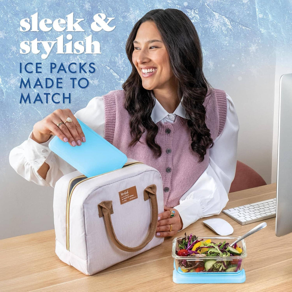 Blue slim reusable ice pack placed into an insulated lunch bag next to a computer
