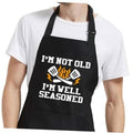 Men's black grilling apron with 'I'm not old, I'm well seasoned' graphic