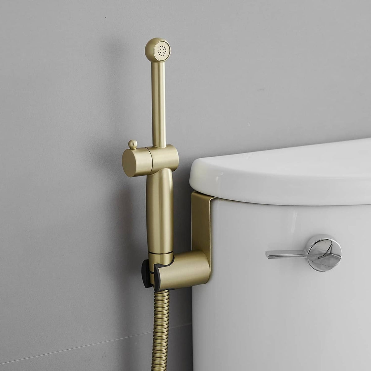 Gold bidet sprayer set attached to toilet tank with handheld shower head and hose