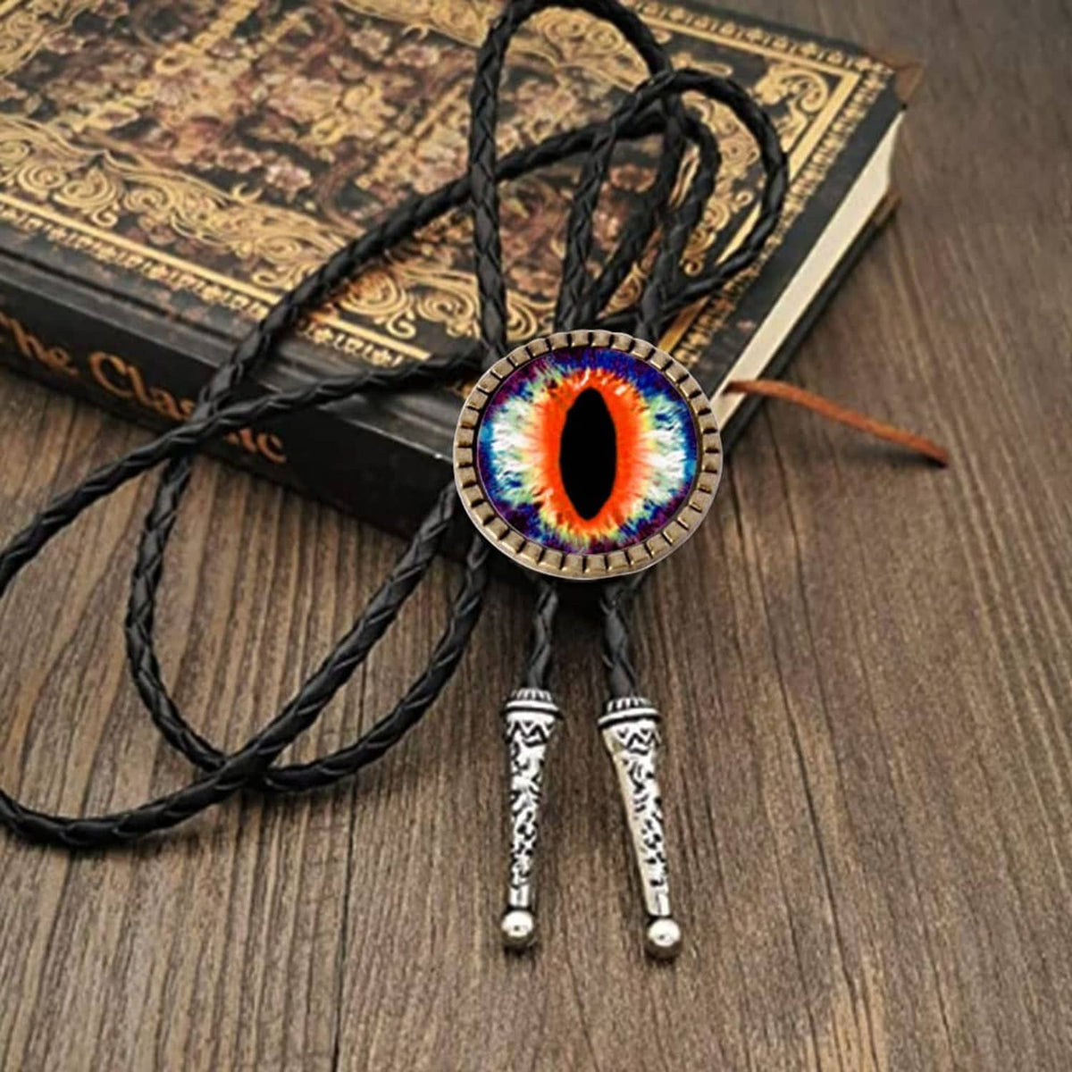Round multicolor evil-eye bolo tie buckle with black braided cords and tips