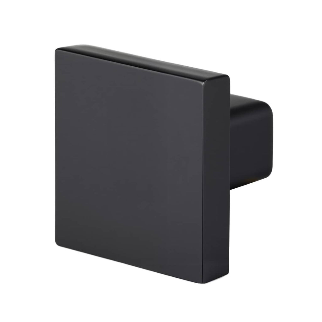 Square black cabinet knob close-up with smooth face and side stem