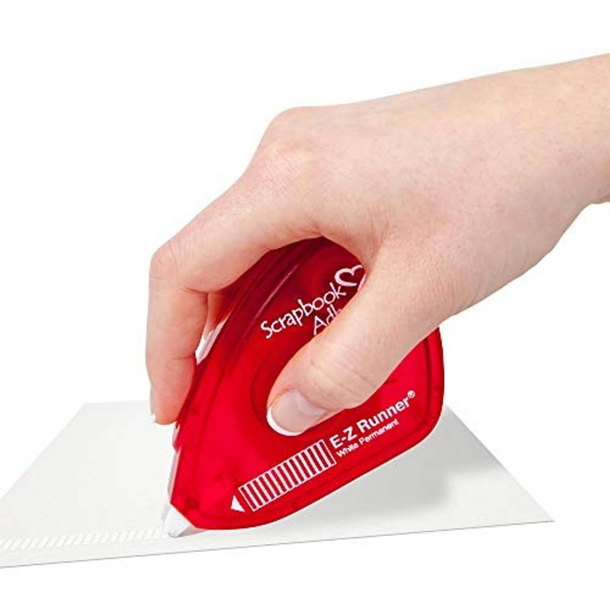 Hand using red E-z Runner permanent adhesive applicator on paper