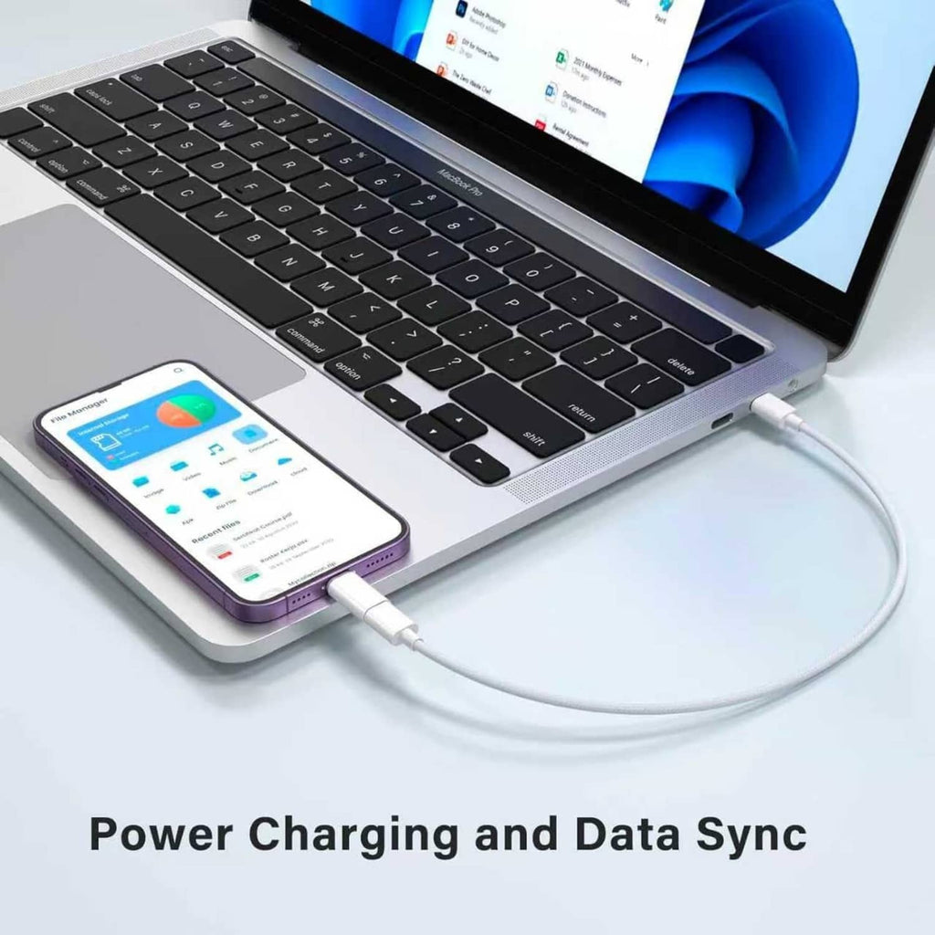 White USB-C to Lightning adapter connecting phone to a laptop for charging and data