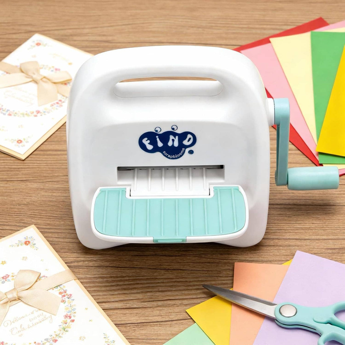 White mini die cutting machine with teal lever and front cutting slot visible