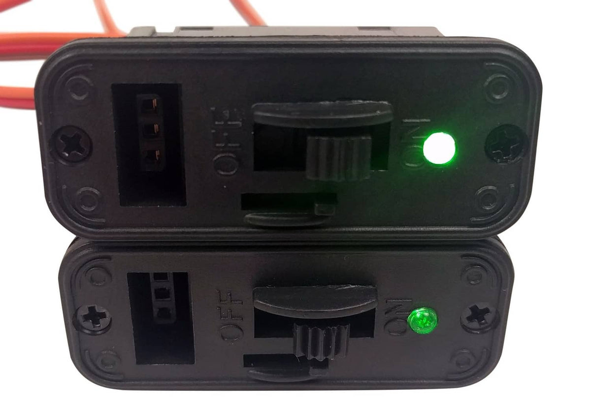 Close-up of black RC on/off switch module with green LED and port openings