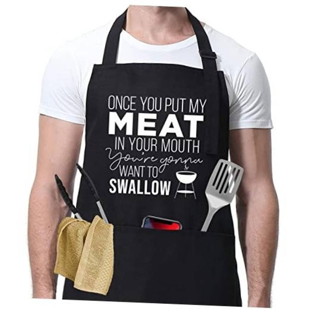 Black cooking apron with funny "MEAT...SWALLOW" grill slogan and fork/utensil graphic.