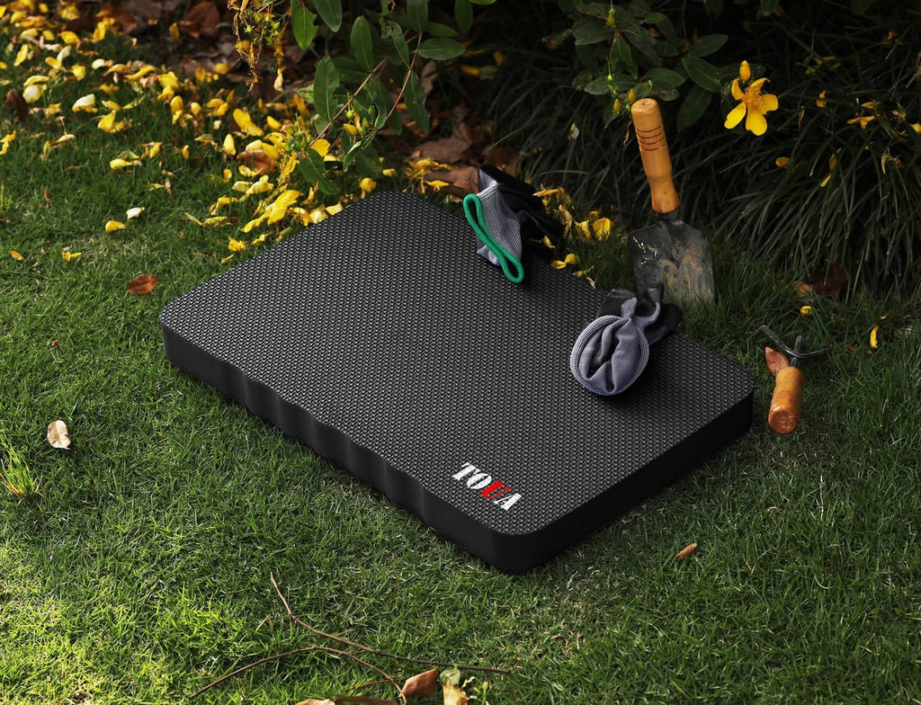 Large dark gray kneeling pad with textured top and carry handle, corner close-up view.