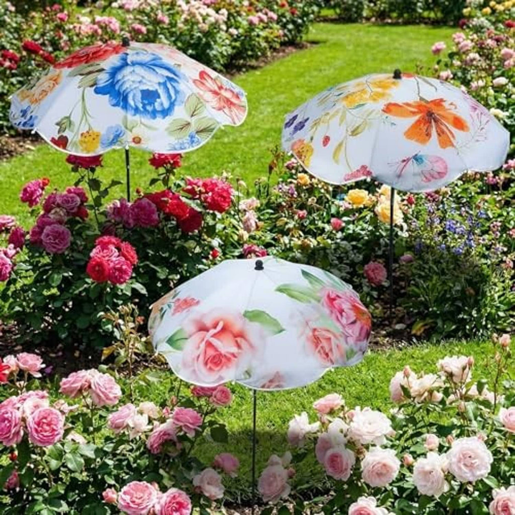 Three floral plant umbrellas on slender poles above blooming rose bushes