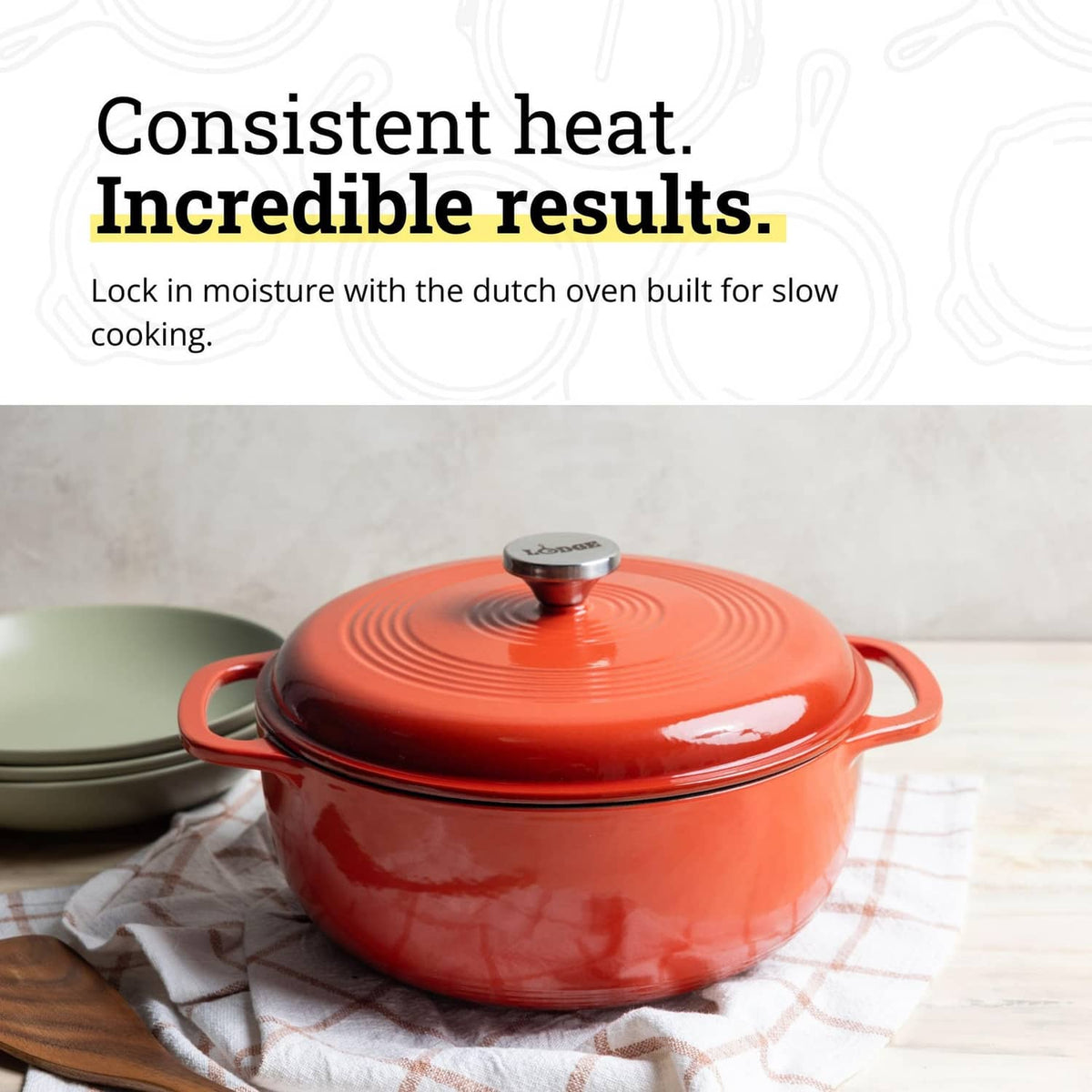 Red enamel cast iron Dutch oven with knobbed lid and side handles on countertop