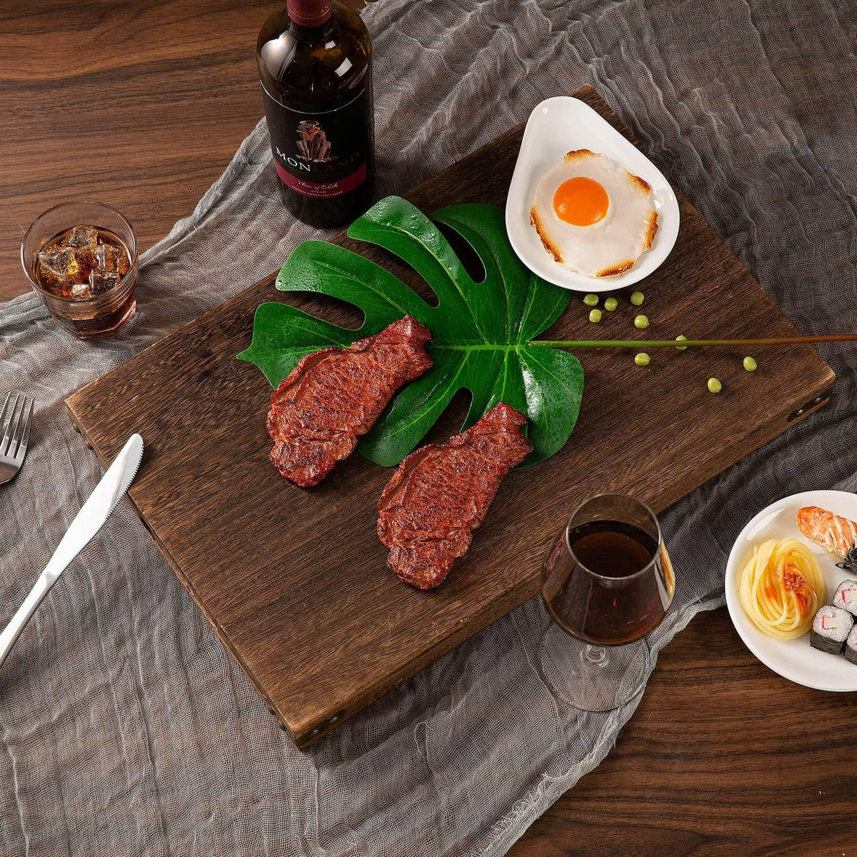 Rustic wooden serving tray with handle cutouts arranged on table with food