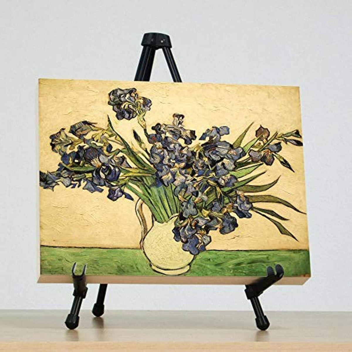 Tabletop easel stand holding a canvas panel with floral artwork and side clamps