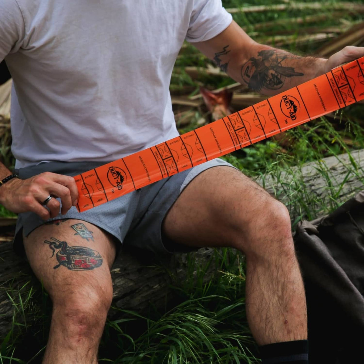 Orange first aid duct tape splint wrapped on a leg for support and closure