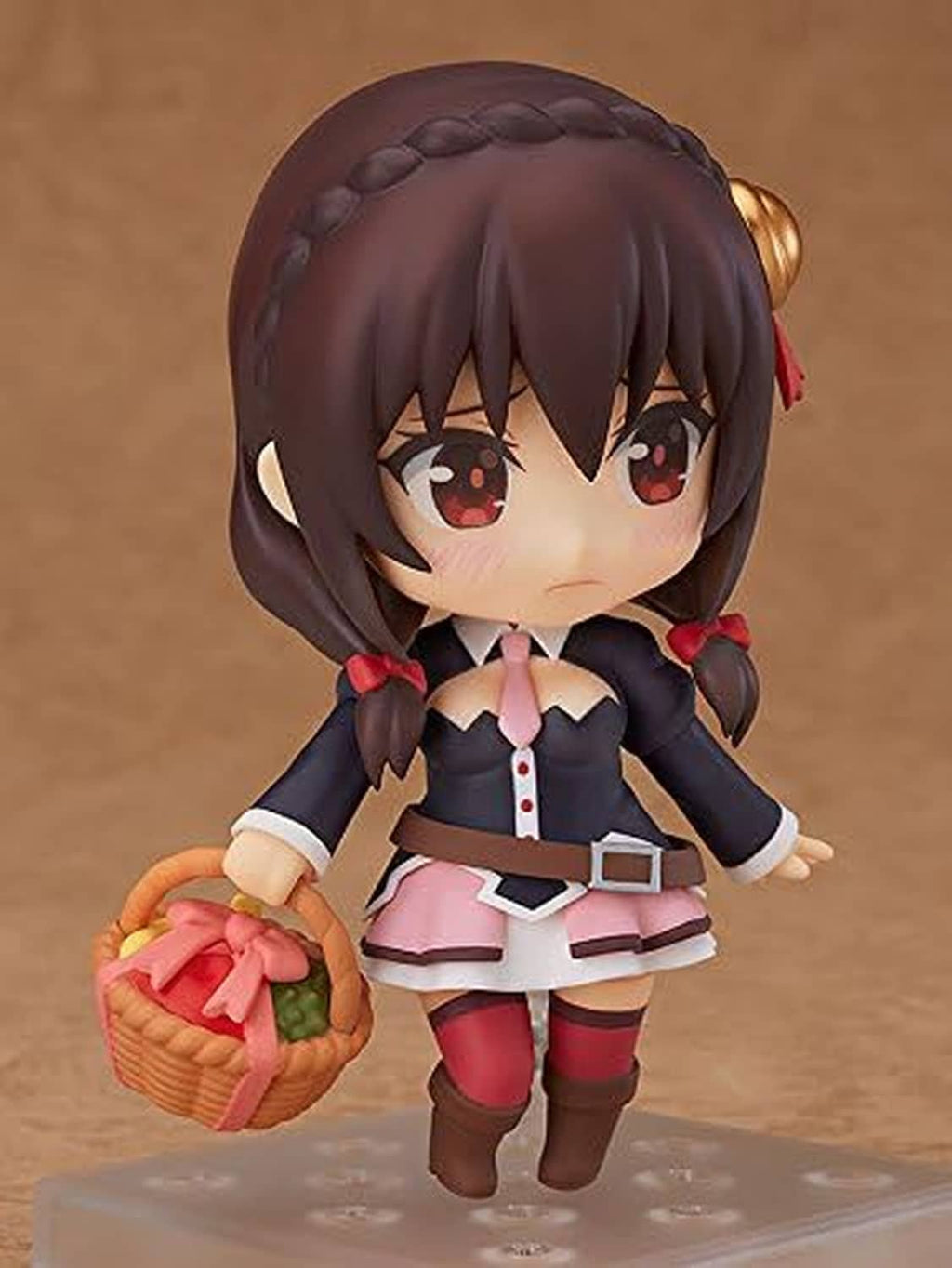Chibi Nendoroid figure holding a small orange basket; dark hair, red eyes, pink skirt.