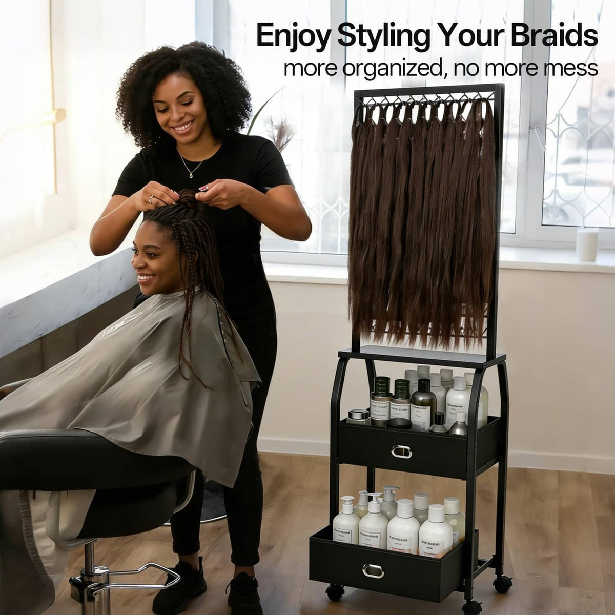 Black braiding hair rack with hanging hair strands and storage drawers on wheeled base