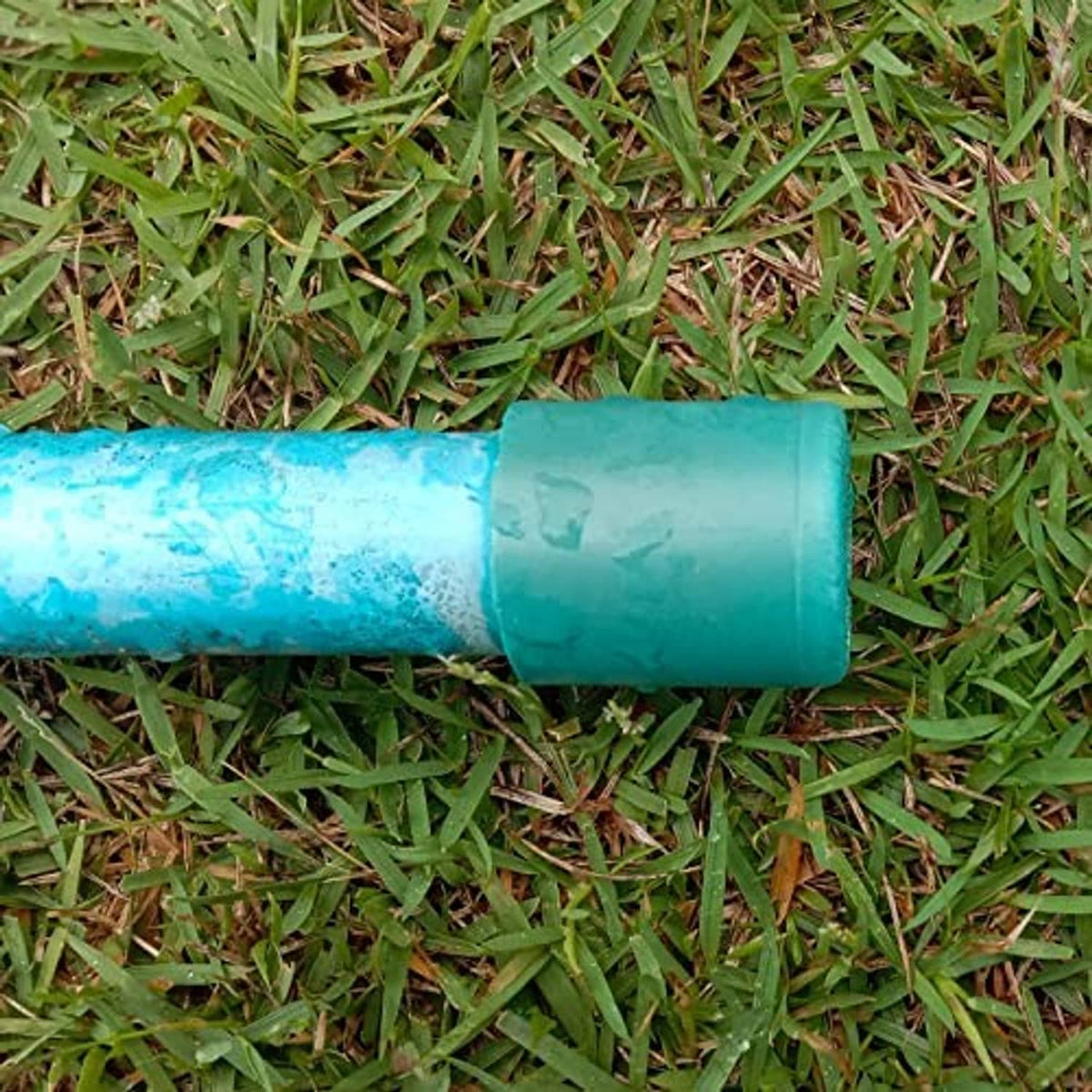PVC pipe end cap fitting on a turquoise pipe section