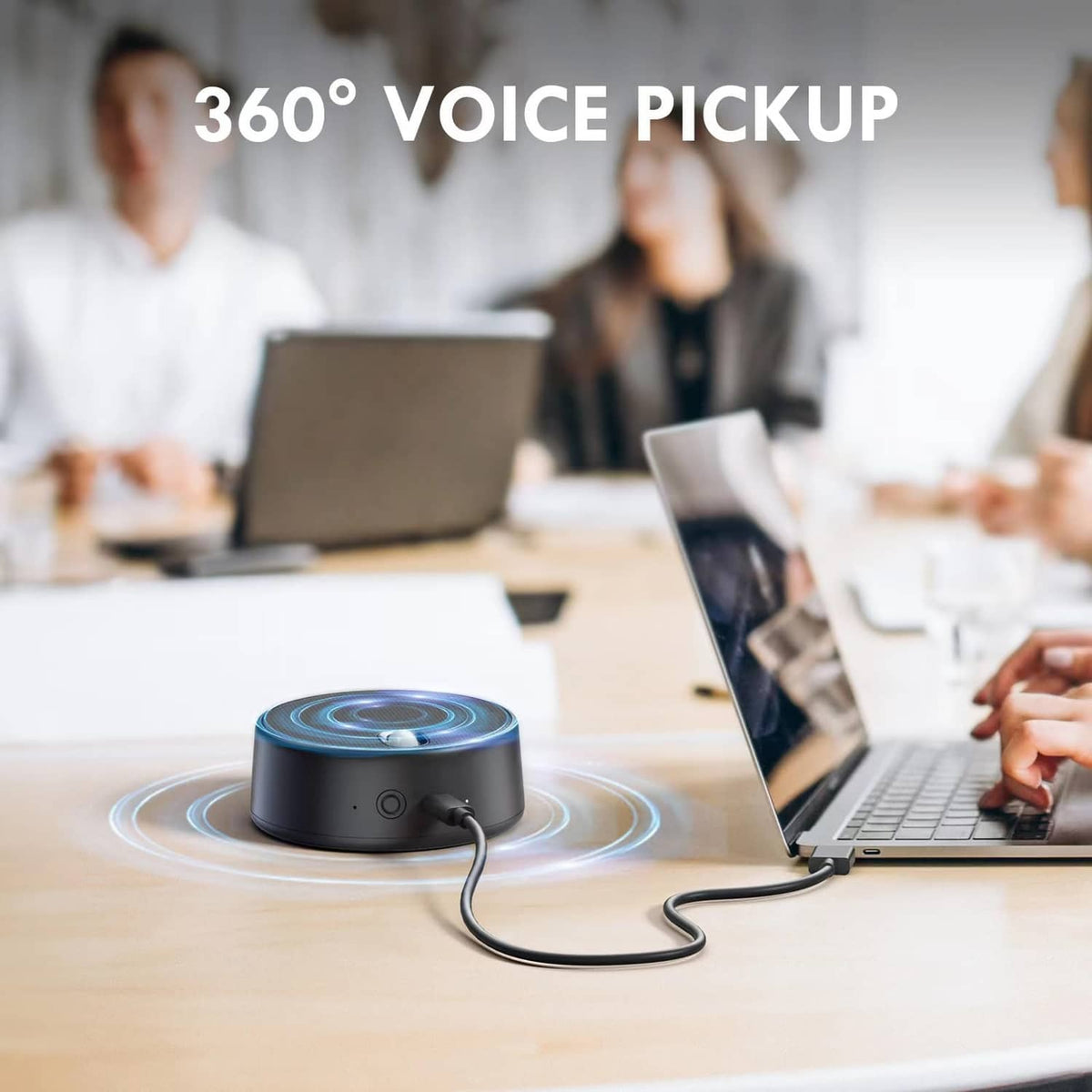 Small black USB speaker on desk with power cord connected to a laptop