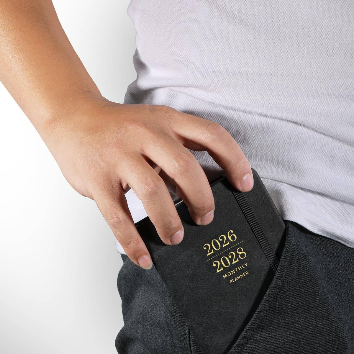 Dark pocket calendar with “2026–2028 Monthly Planner” cover, hand holding front elastic pocket