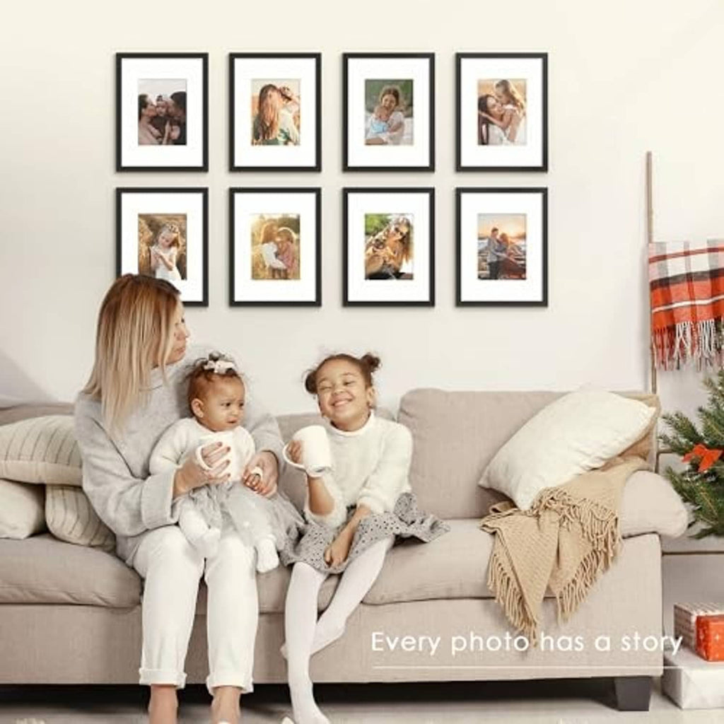 Black picture frame set on wall above a sofa, with family photos in small frames