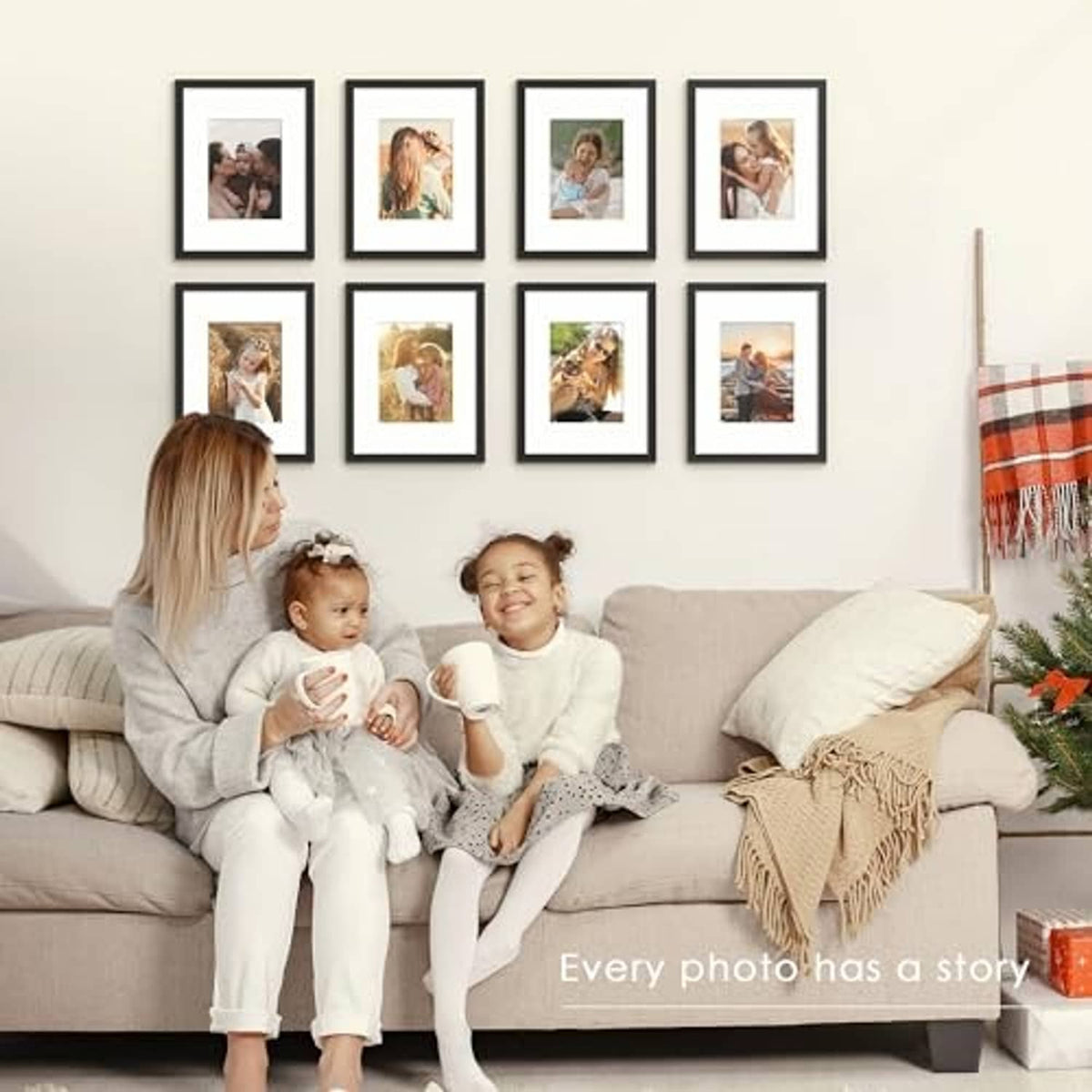 Black picture frame set on wall above a sofa, with family photos in small frames
