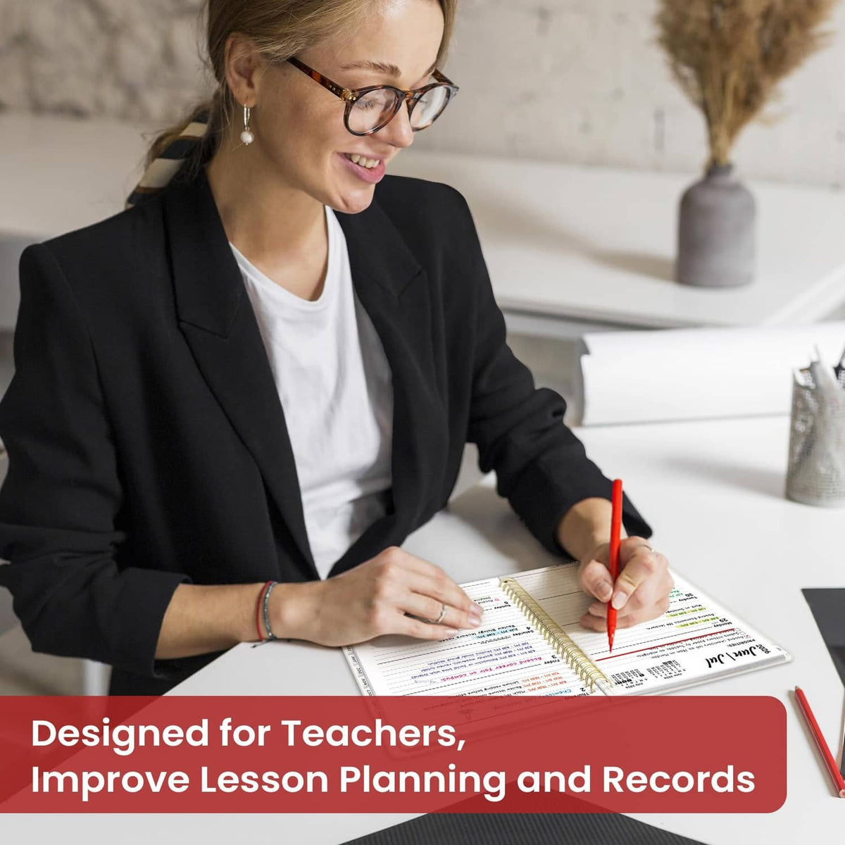 Teacher writing in an open planner with a calendar grid for lesson planning