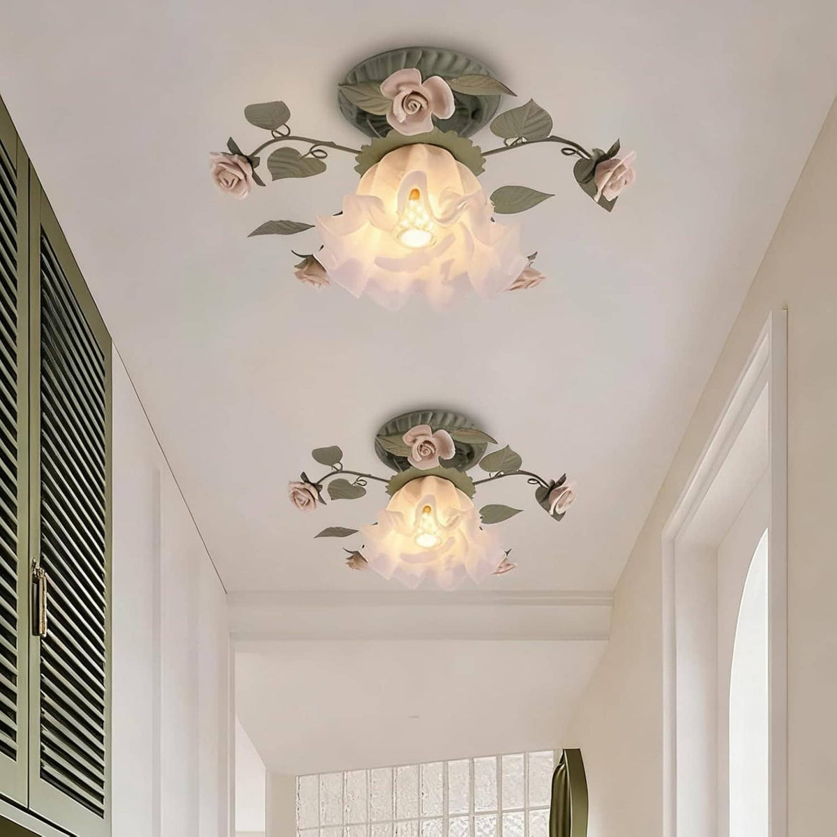 Two floral semi-flush ceiling lights with green leaf metal frames and white glass rose shades