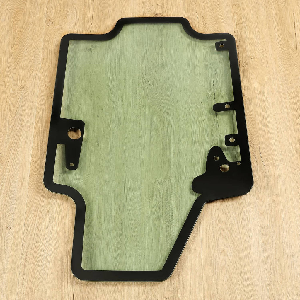 Skid steer door glass panel with black frame and side latch brackets, tinted light green