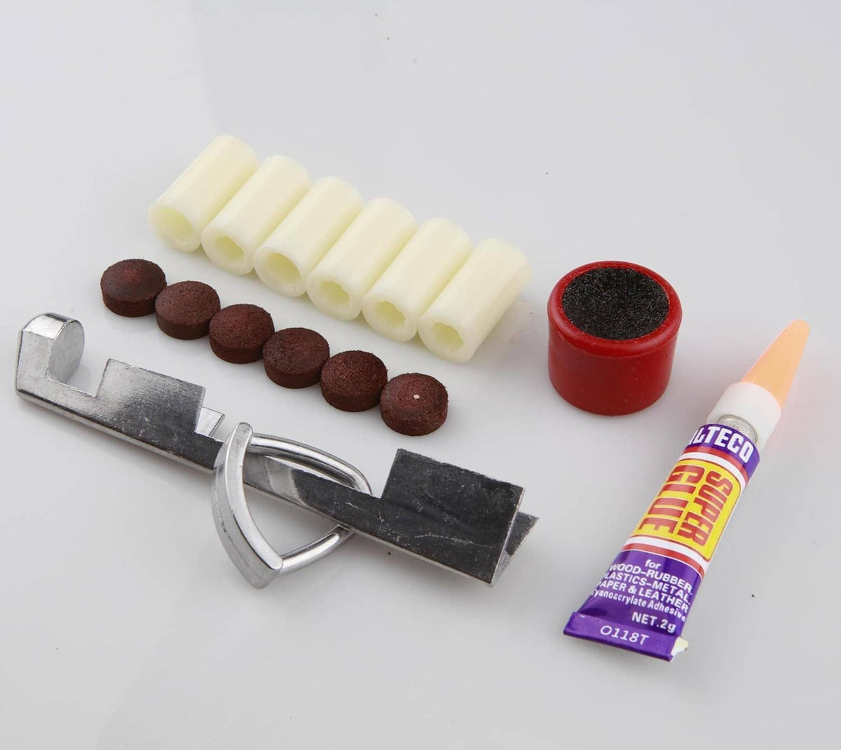 Cue tip repair kit contents: pale tips, dark brown tips, metal clamp tool, red cap, glue tube