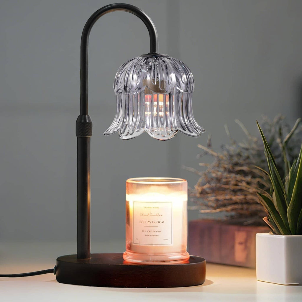 Black candle warmer lamp with ribbed glass shade and glowing candle on round base