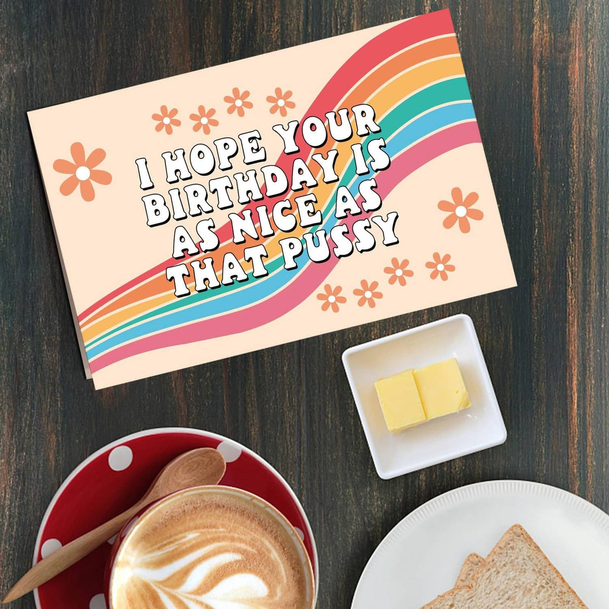 Funny birthday card with rainbow and flowers; message reads “I hope your birthday is as nice as that pussy”