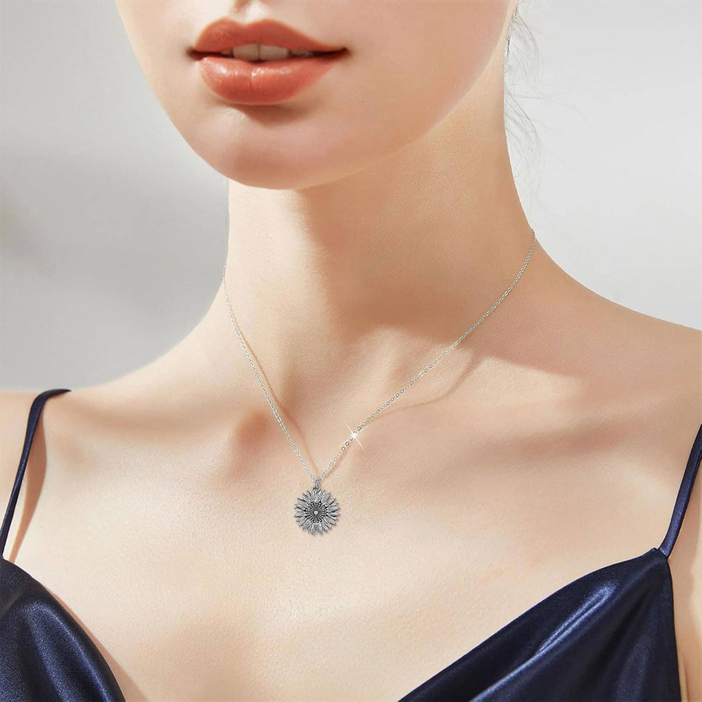 Sterling silver necklace with small circular sunflower-style pendant and engraved text