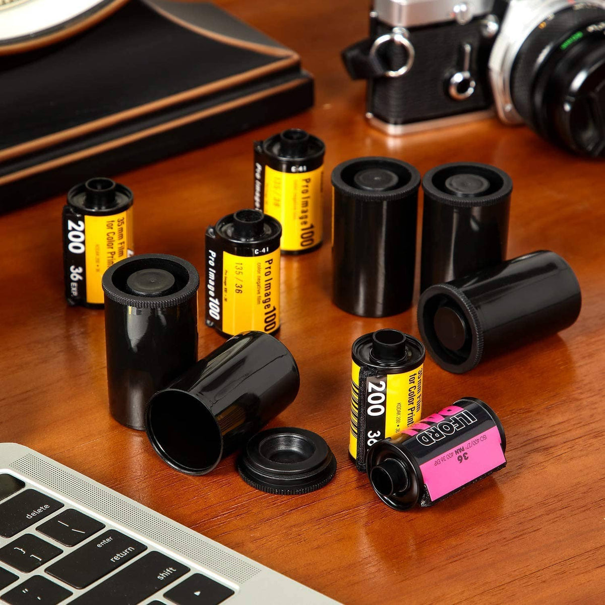 Black plastic film canisters with lids and rolled film, assorted pieces