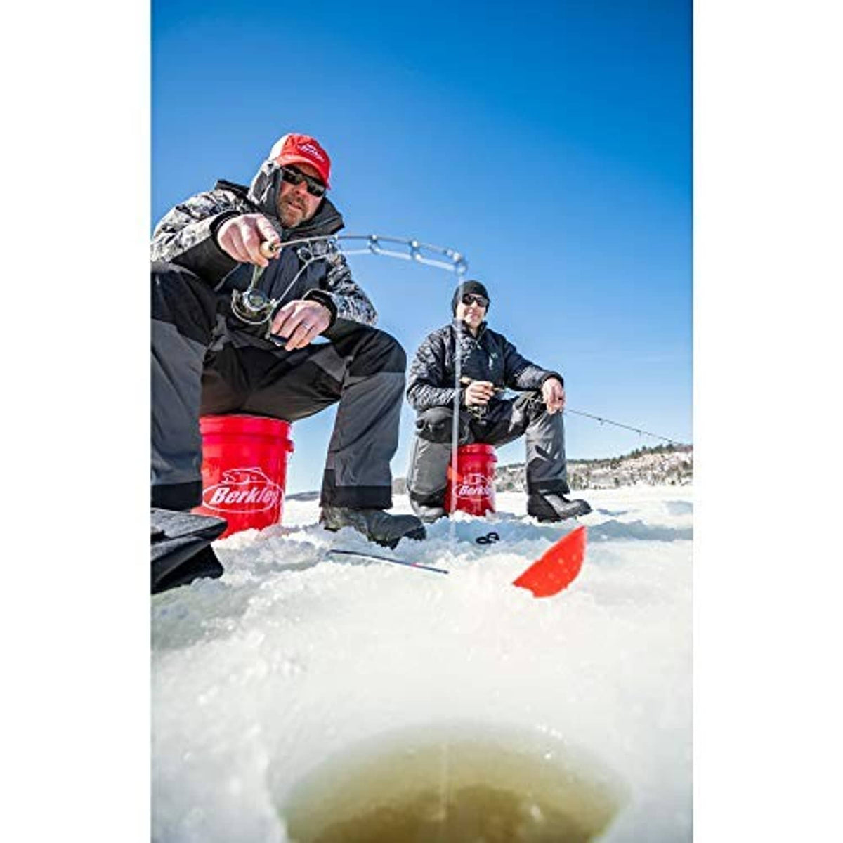 Ice fishing anglers holding rods with fishing line and red tackle buckets