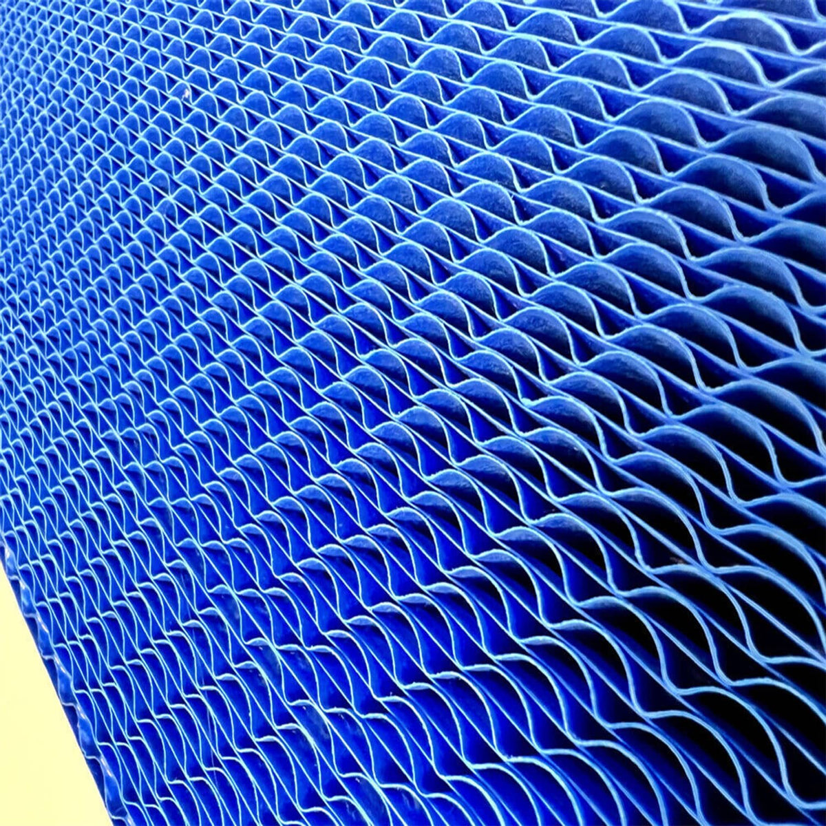 Blue pleated engine air filter media with fine mesh texture, close-up