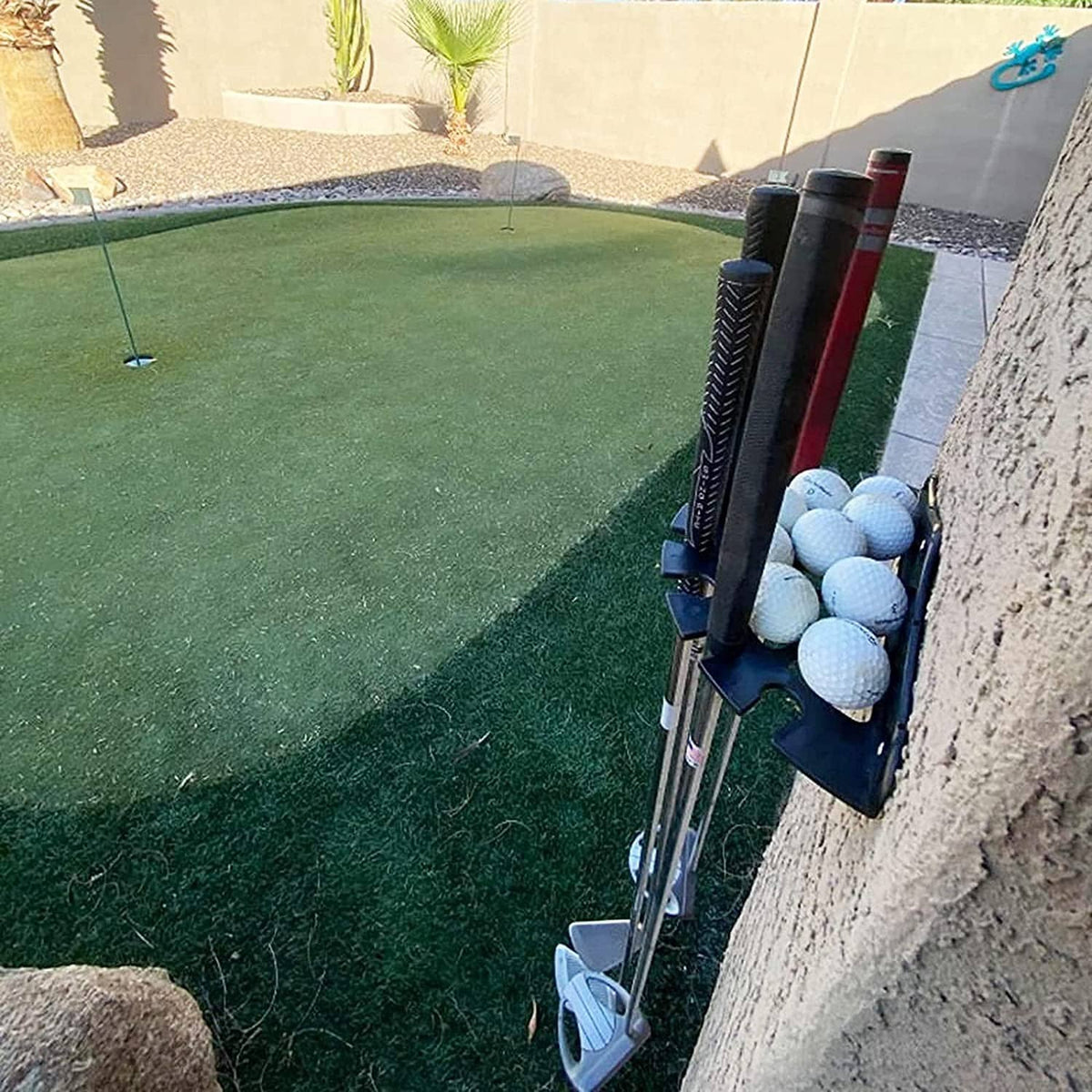 Black golf putter rack holding club shafts and white golf balls along the holders.