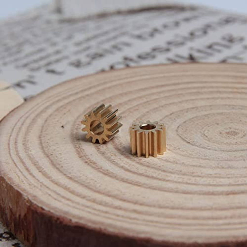 Two small 12-tooth spur gears with 3 mm bores on a wooden slice